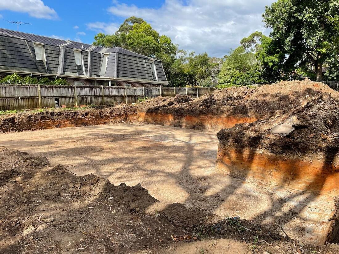 Pool dig in orange clay with tight-access machinery